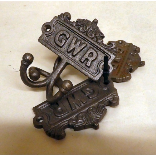 185 - A set of three cast iron, twin handled coat hooks, branded for 'GWR'  each 4