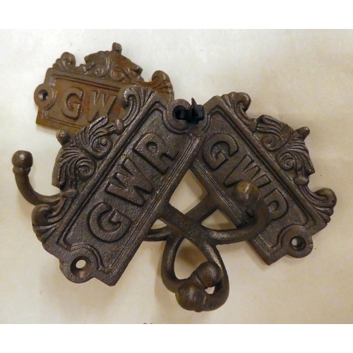 185 - A set of three cast iron, twin handled coat hooks, branded for 'GWR'  each 4