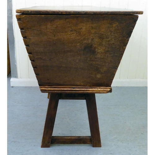 23 - A late 18th/early 19thC elm dough bin with angled sides and a removeable lid, raised on square legs&... 