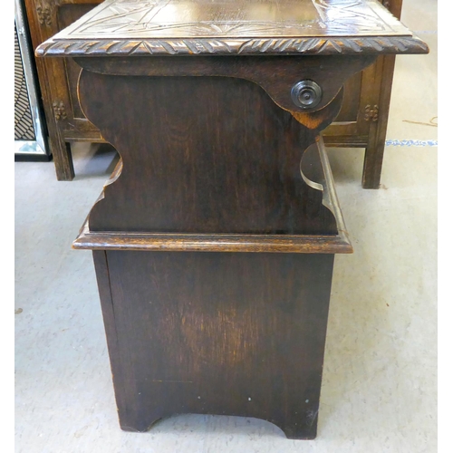 24 - A 1930s stained oak monk's bench with a hinged seat, over a carved and panelled front  30