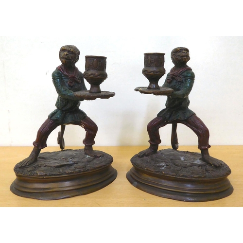 245 - A pair of modern cast bronze novelty candlesticks, fashioned as monkeys', in servant robes, on an ov... 