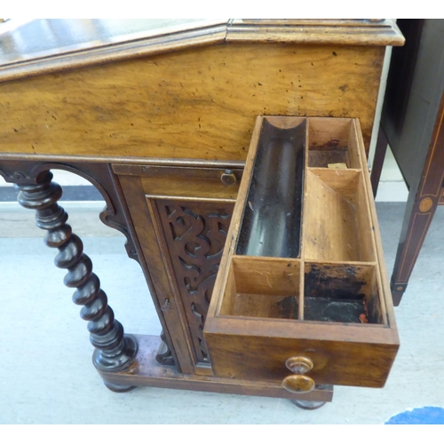 25 - A mid Victorian mahogany and walnut Davenport with a fret carved gallery, over a hide scriber set to... 