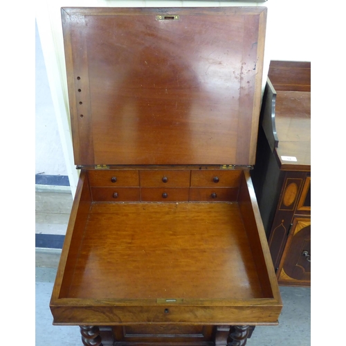 25 - A mid Victorian mahogany and walnut Davenport with a fret carved gallery, over a hide scriber set to... 