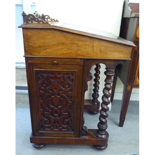 25 - A mid Victorian mahogany and walnut Davenport with a fret carved gallery, over a hide scriber set to... 