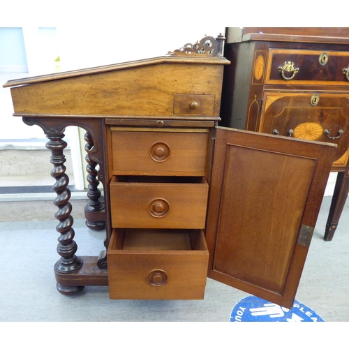 25 - A mid Victorian mahogany and walnut Davenport with a fret carved gallery, over a hide scriber set to... 