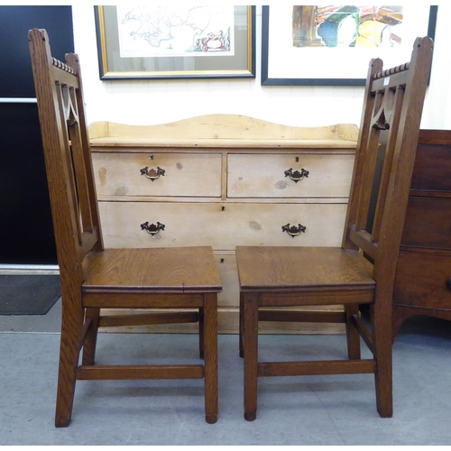 263 - A pair of late Victorian Arts & Crafts Pugin inspired, oak framed hall chairs, each with a caste... 