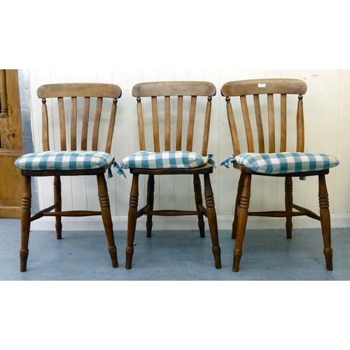 275 - A set of three modern Windsor beech and elm framed kitchen chairs with solid seats, raised on ring t... 