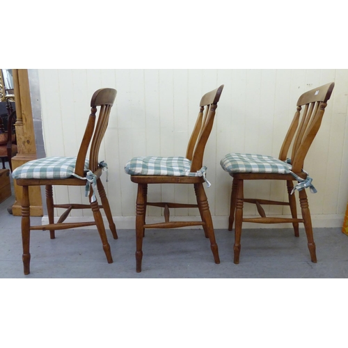 275 - A set of three modern Windsor beech and elm framed kitchen chairs with solid seats, raised on ring t... 