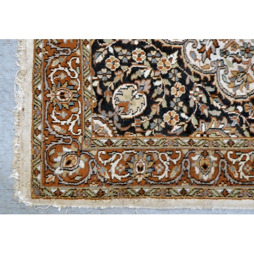 286 - A Persian rug, decorated with a serpentine outlined central motif, bordered by floral designs, on a ... 