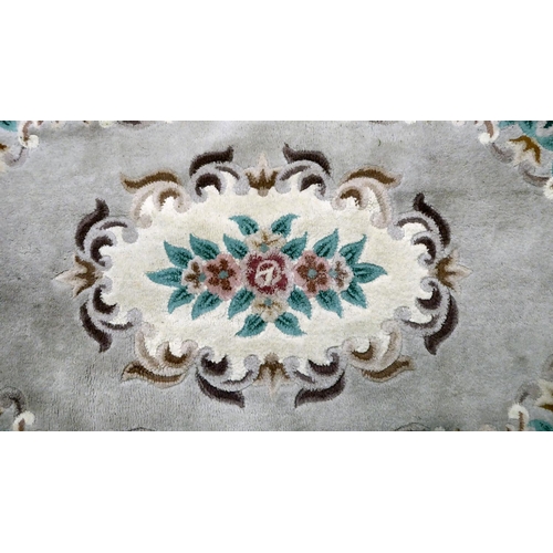 287 - A Chinese washed woollen rug, decorated with flora, in pastel tones  45