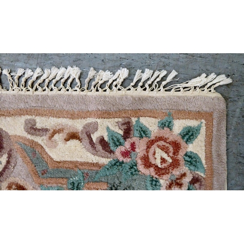 287 - A Chinese washed woollen rug, decorated with flora, in pastel tones  45