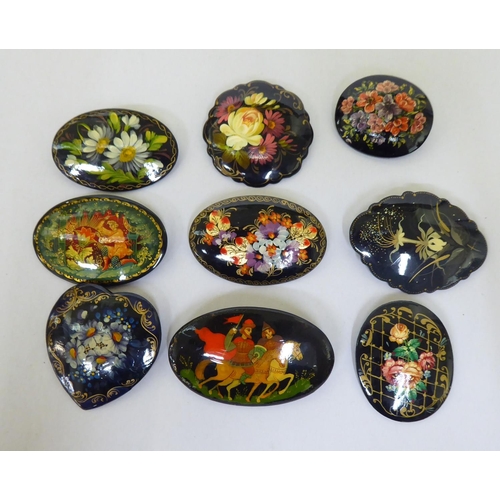 301 - Nine Russian painted papier mache brooches, decorated with various scenes