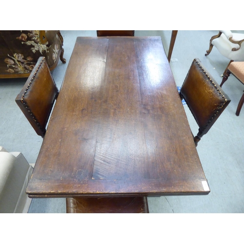 31 - An early/mid 20thC English style oak draw-leaf dining table, over a foliage carved frieze, turned an... 