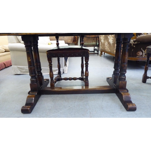 31 - An early/mid 20thC English style oak draw-leaf dining table, over a foliage carved frieze, turned an... 