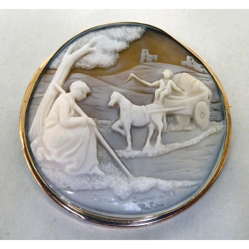 311 - A shell carved cameo brooch, depicting a horse and cart with a shepherd seated beneath a tree, in a ... 