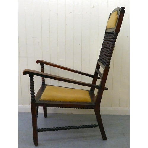 32 - An Arts & Crafts period mahogany and stained beech framed chair with bobbin turned features and ... 