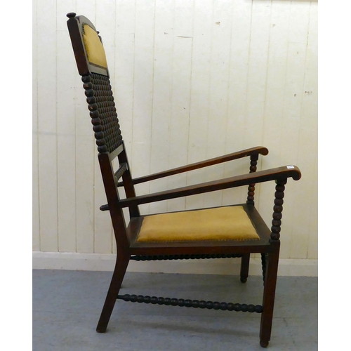 32 - An Arts & Crafts period mahogany and stained beech framed chair with bobbin turned features and ... 