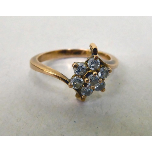 339 - A yellow metal crossover ring, set with white stones