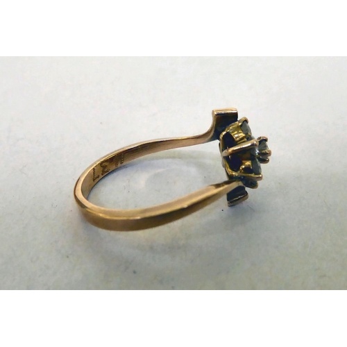 339 - A yellow metal crossover ring, set with white stones