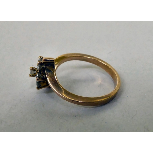 339 - A yellow metal crossover ring, set with white stones