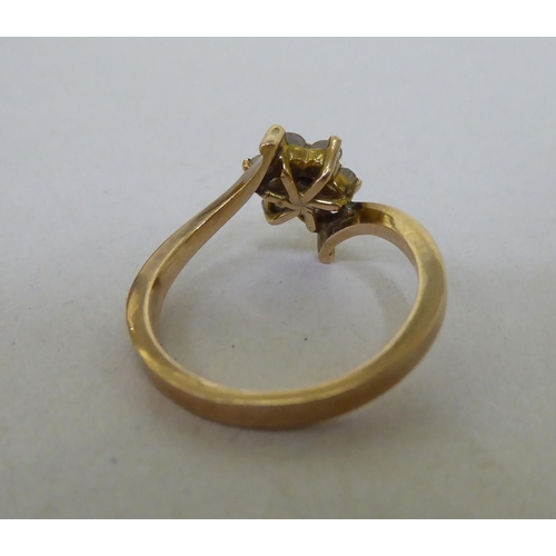 339 - A yellow metal crossover ring, set with white stones