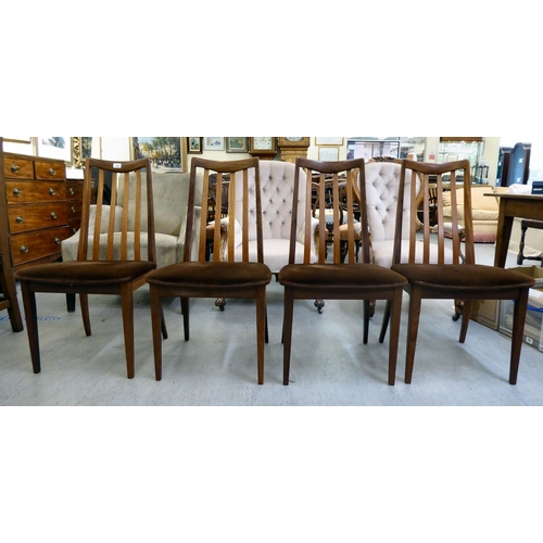 346 - A set of four G-Plan teak framed dining chairs, each with a slatted back and upholstered seat, raise... 