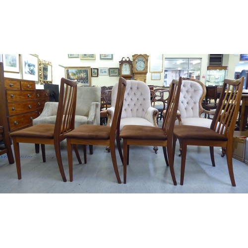 346 - A set of four G-Plan teak framed dining chairs, each with a slatted back and upholstered seat, raise... 