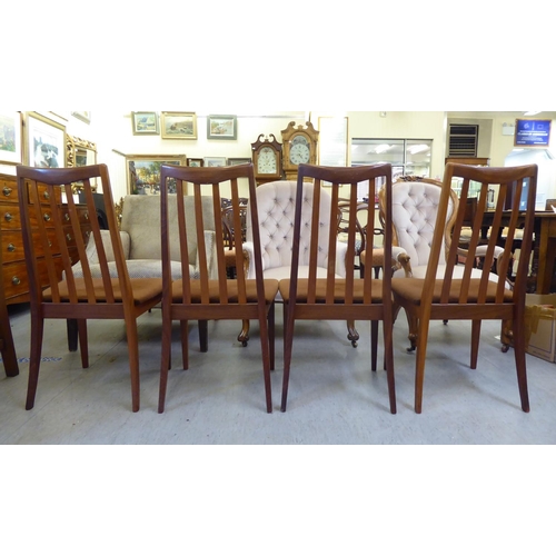 346 - A set of four G-Plan teak framed dining chairs, each with a slatted back and upholstered seat, raise... 