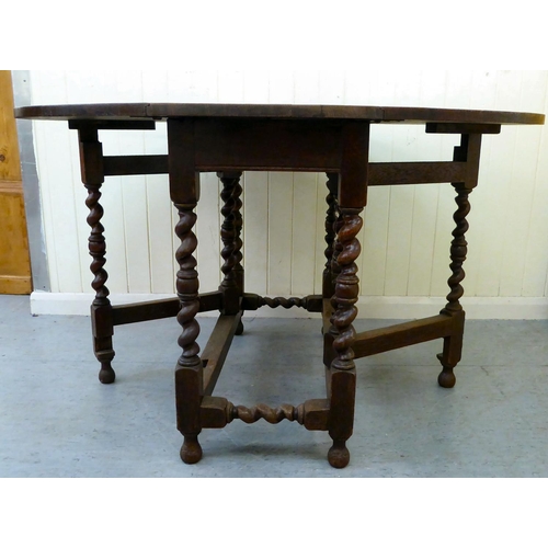 46 - An early 20thC oak gateleg drop-leaf table, raised on barleytwist and block supports  29