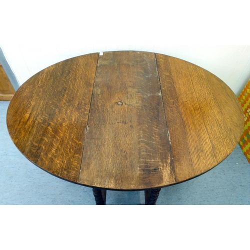 46 - An early 20thC oak gateleg drop-leaf table, raised on barleytwist and block supports  29