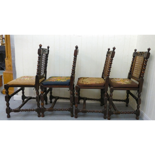 48 - A set of four early/mid 20thC stained, carved and turned, beech framed dining chairs with caned back... 