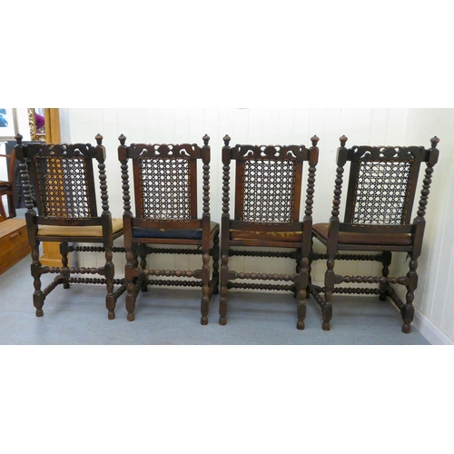 48 - A set of four early/mid 20thC stained, carved and turned, beech framed dining chairs with caned back... 