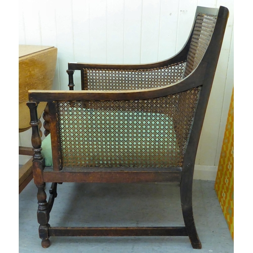 52 - Small furniture: to include an early 20thC mahogany showwood framed bergere chair, raised on turned ... 