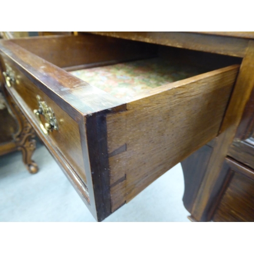 53 - A late Victorian mahogany five drawer kneehole dressing table with a low gallery upstand, raised on ... 