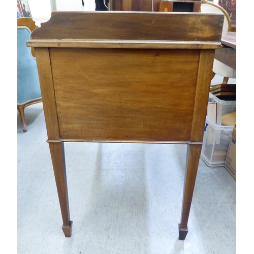 53 - A late Victorian mahogany five drawer kneehole dressing table with a low gallery upstand, raised on ... 