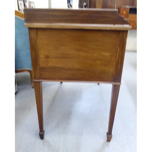 53 - A late Victorian mahogany five drawer kneehole dressing table with a low gallery upstand, raised on ... 