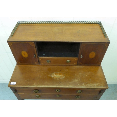 55 - An Edwardian mahogany bureau with a gallery, over an open shelf and drawer, flanked by two cupboard ... 