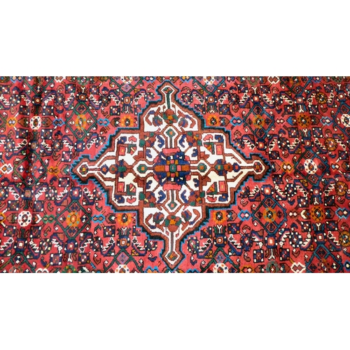 76 - A Persian design carpet, decorated with a central medallion, surrounded by geometric patterns and bo... 