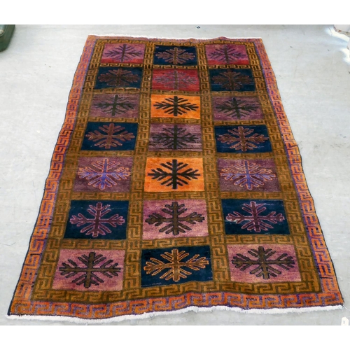 81 - An Iranian rug, decorated with twenty-one panels and snowflake design motifs, on a multi-coloured gr... 