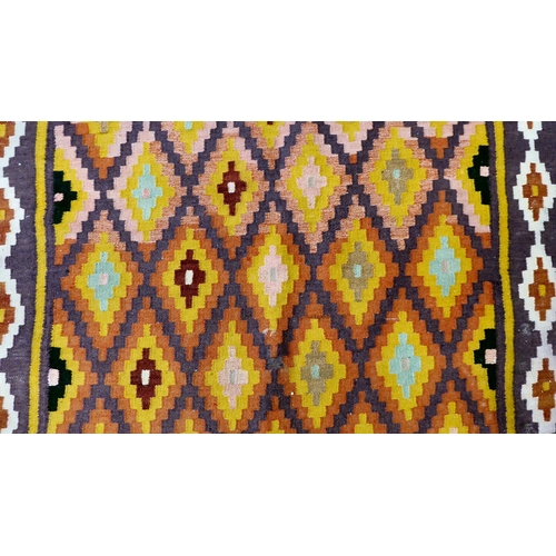 86 - A Kelim design rug, decorated with geometric patterns, on a purple ground  112