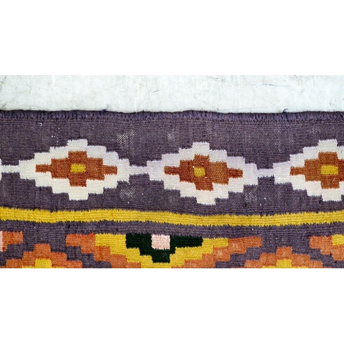 86 - A Kelim design rug, decorated with geometric patterns, on a purple ground  112