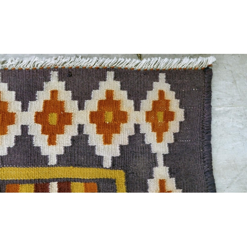 86 - A Kelim design rug, decorated with geometric patterns, on a purple ground  112