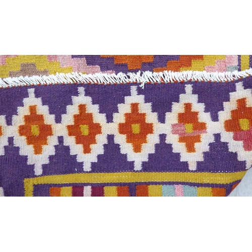 86 - A Kelim design rug, decorated with geometric patterns, on a purple ground  112