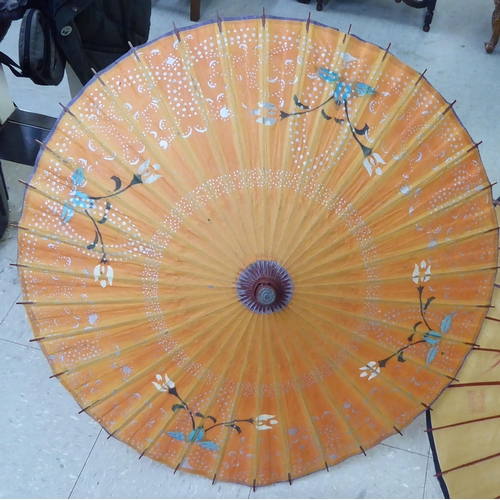 124 - Two 20thC Oriental handpainted paper parasols