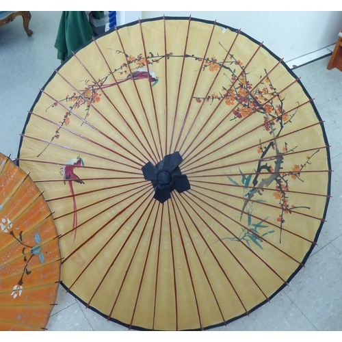 124 - Two 20thC Oriental handpainted paper parasols