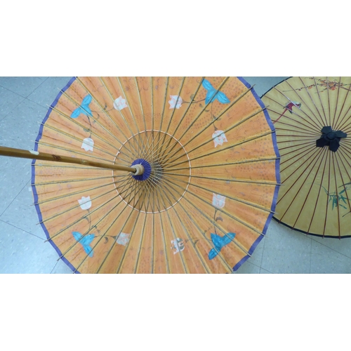 124 - Two 20thC Oriental handpainted paper parasols