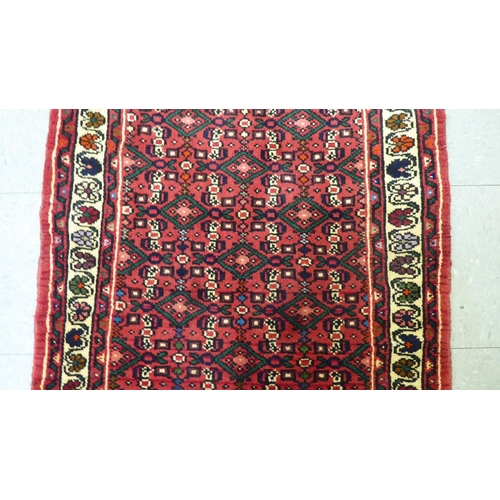 158 - A Persian Hamedan design runner, decorated with geometric and floral patterns, on a red ground  40