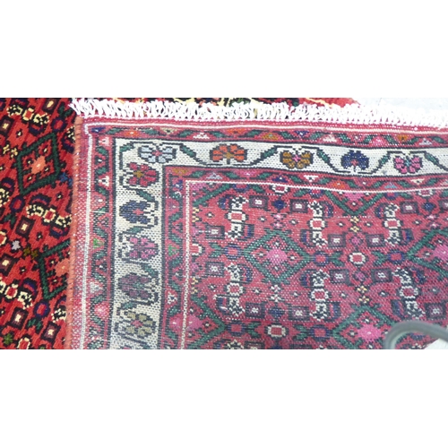 158 - A Persian Hamedan design runner, decorated with geometric and floral patterns, on a red ground  40