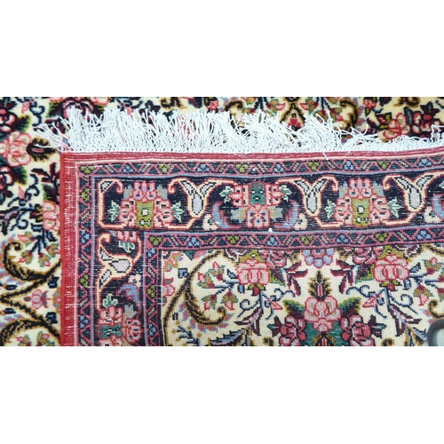 163 - A Persian Keshan design rug, decorated with floral patterns, on a cream and red ground  42