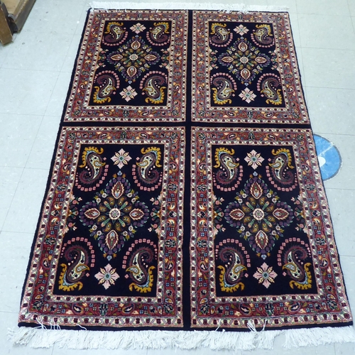 170 - A Persian design rug, decorated with four panels, each filled with floral motifs, on a black ground&... 